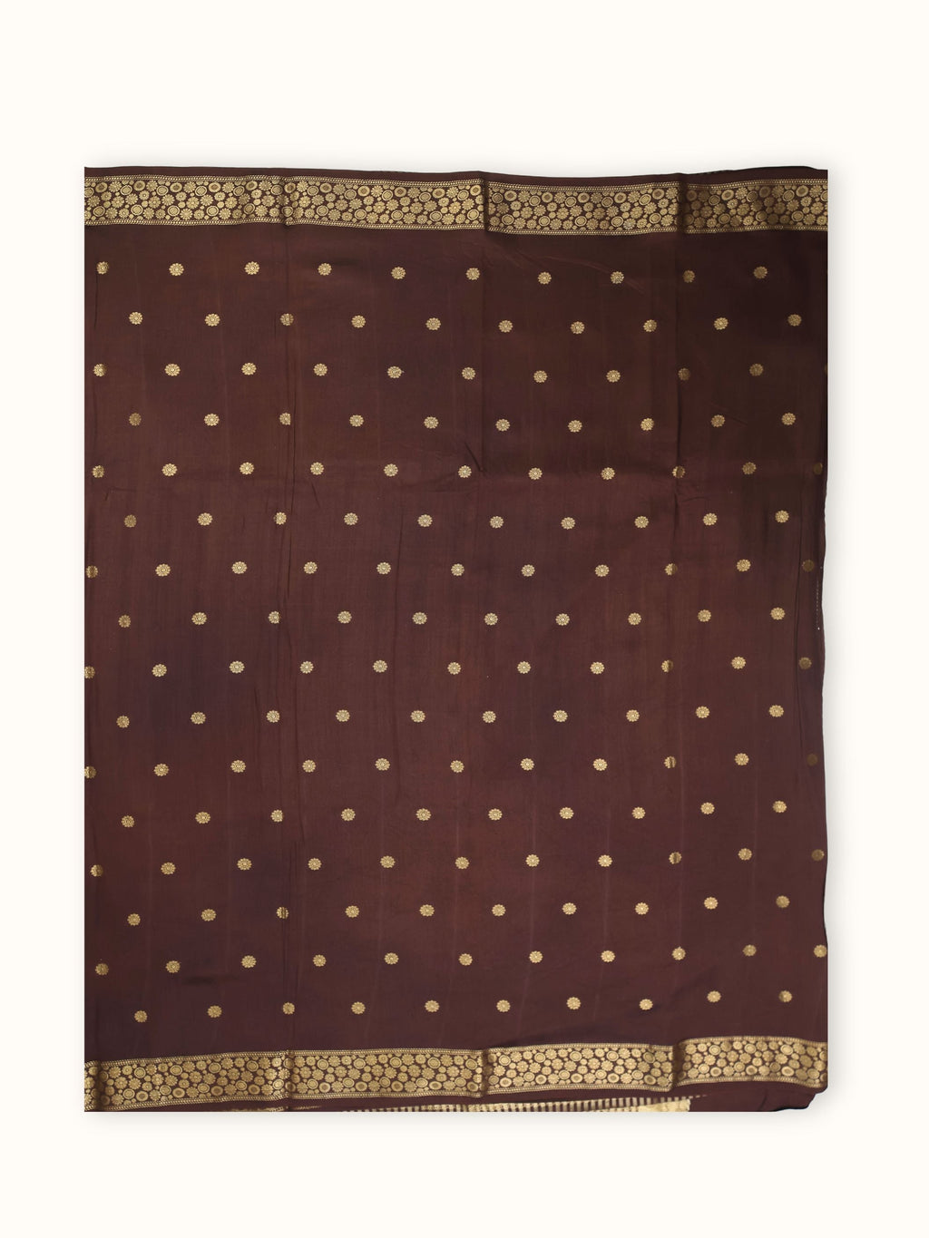 The saree spread flat, gold coins in even rows across the body