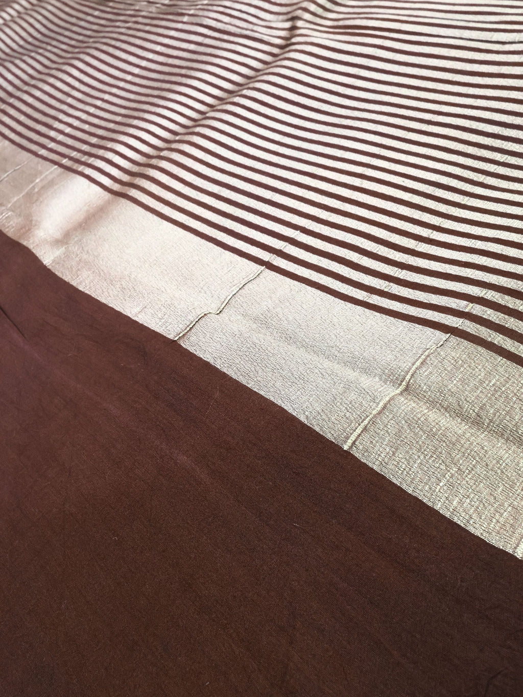 Close detail of the striped gold pallu against coffee brown silk