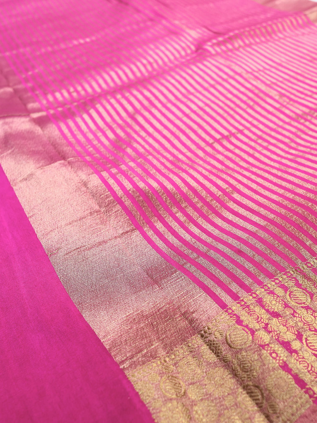 Close detail of the striped gold pallu against fuchsia pink silk