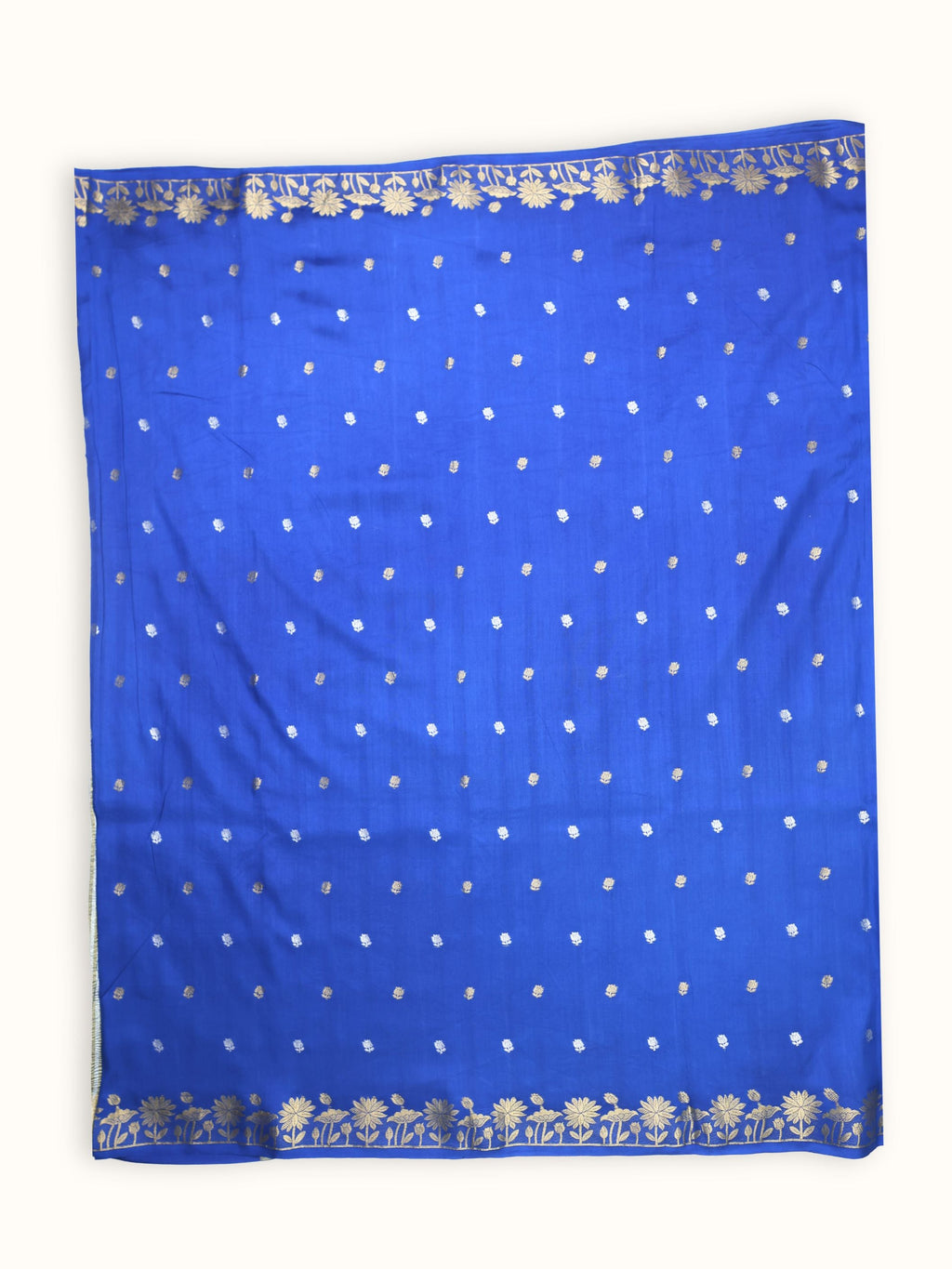 The saree spread flat, small silver butis close across the body