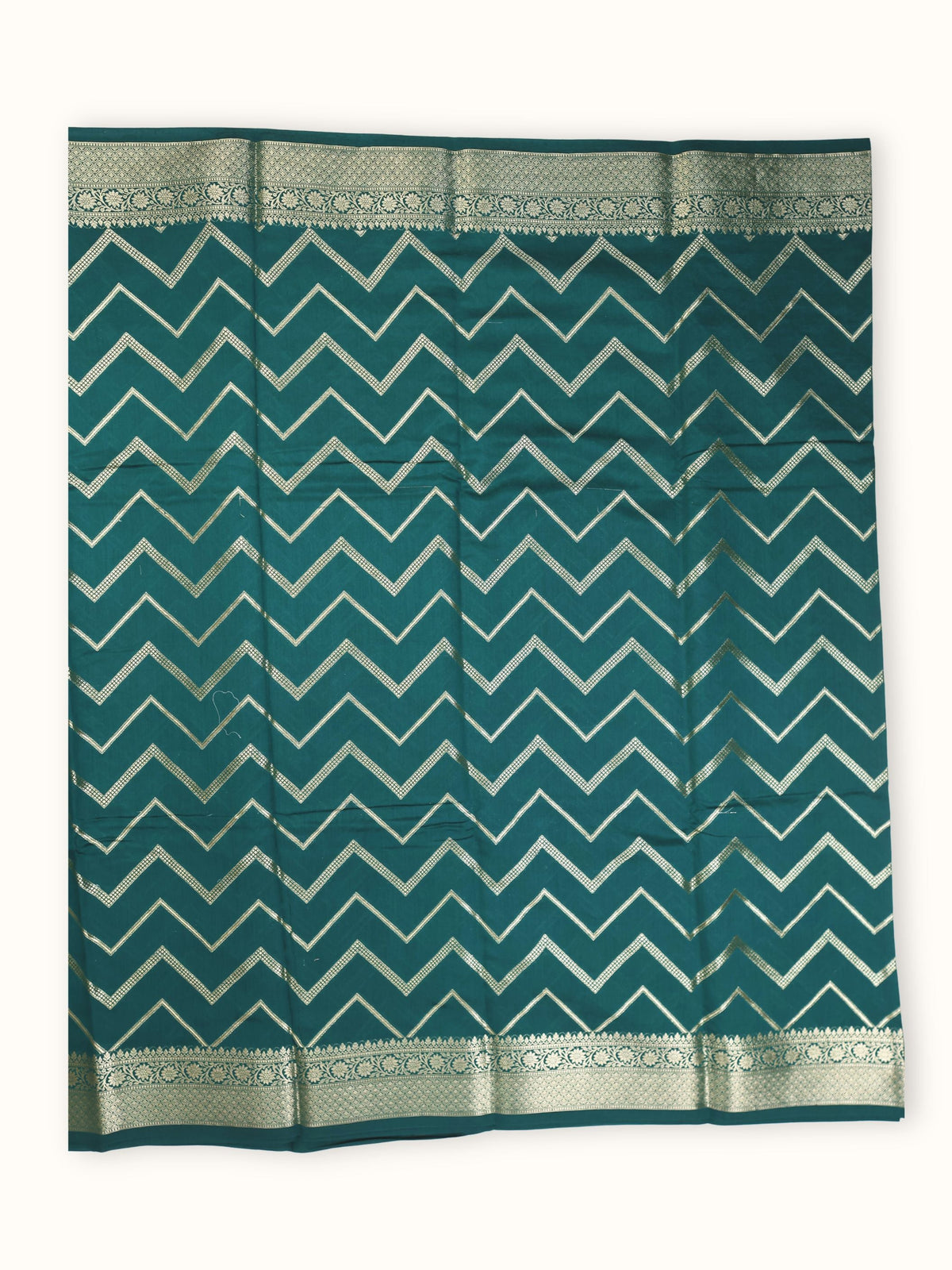The saree spread flat, silver chevron bands running the width
