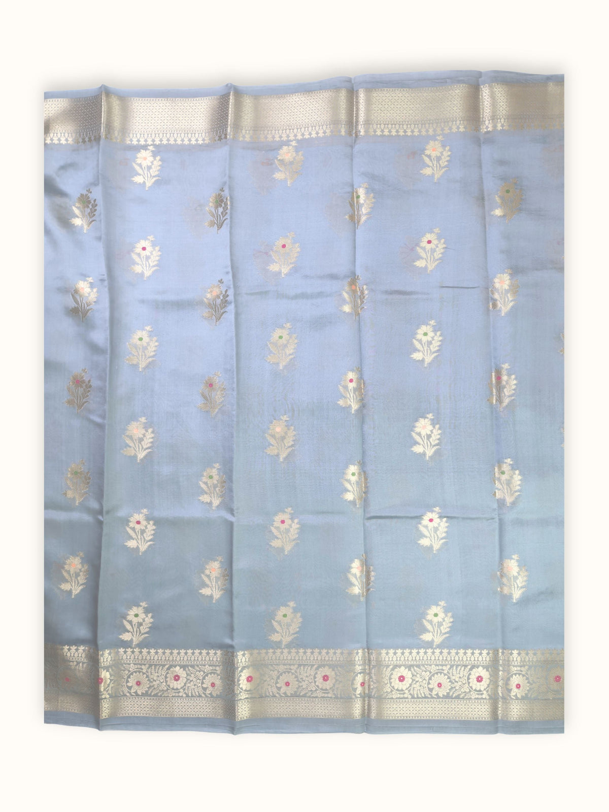 The saree spread flat, gold flowering sprigs in even rows
