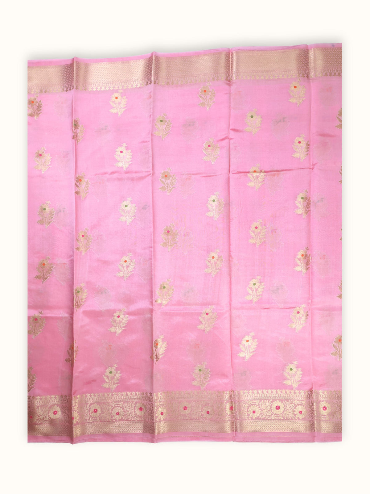The saree spread flat, gold flowering sprigs in even rows