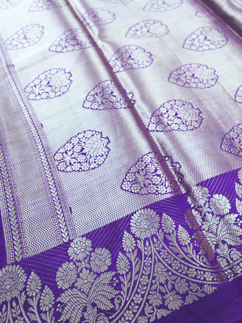 Close detail of the silver paisley work on violet silk