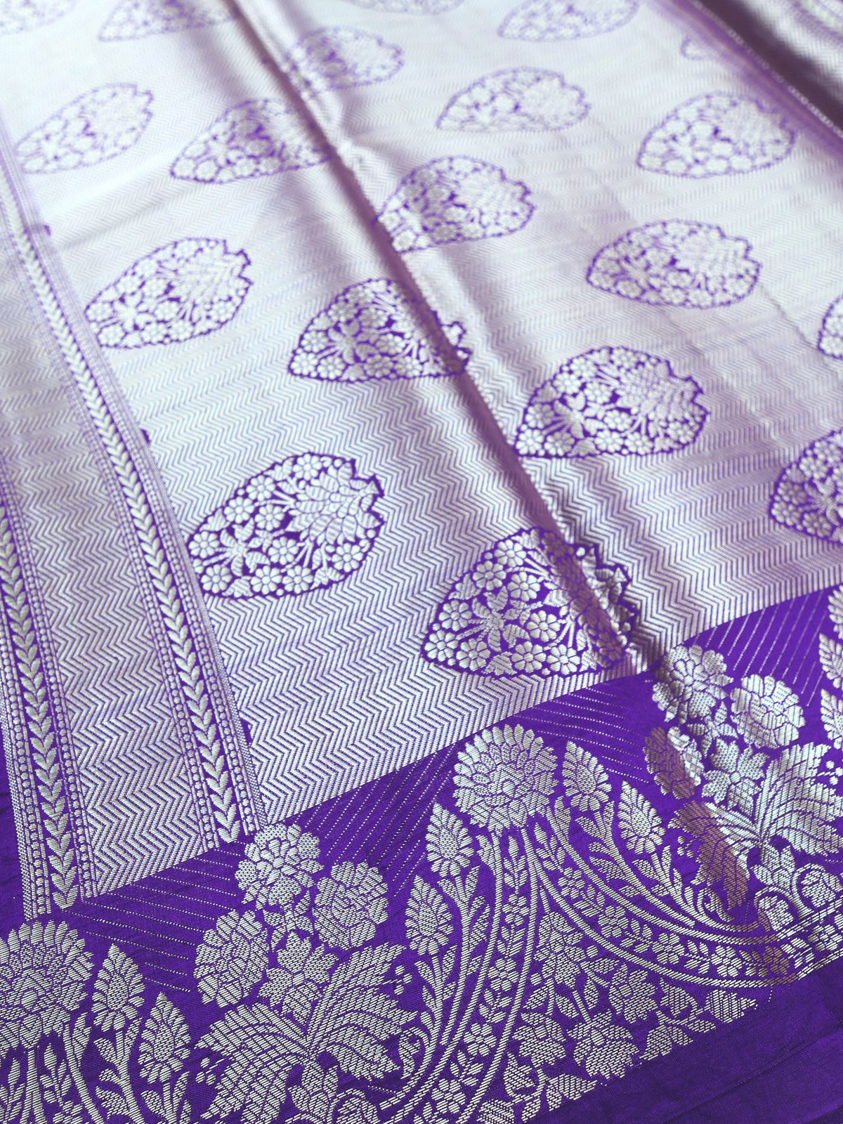 Close detail of the silver paisley work on violet silk