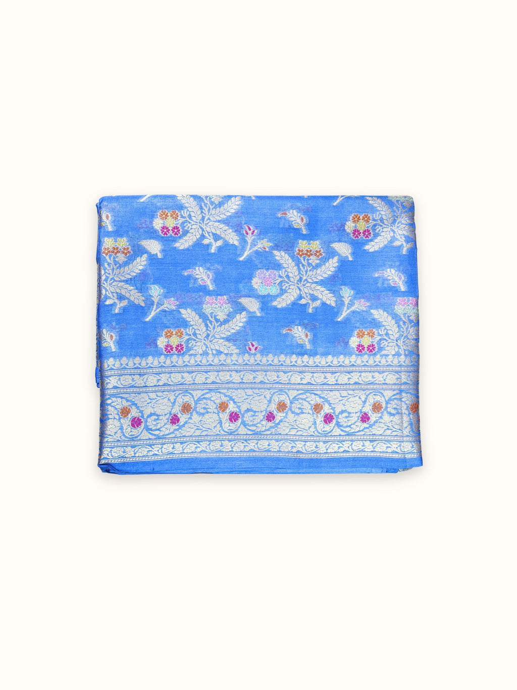 Cornflower blue Tassar silk saree folded, with silver leaf sprays and a floral border