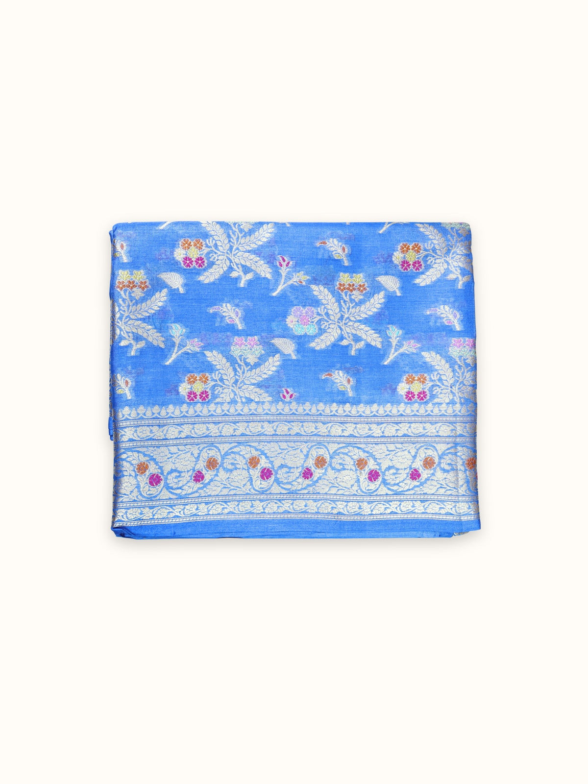 Cornflower blue Tassar silk saree folded, with silver leaf sprays and a floral border