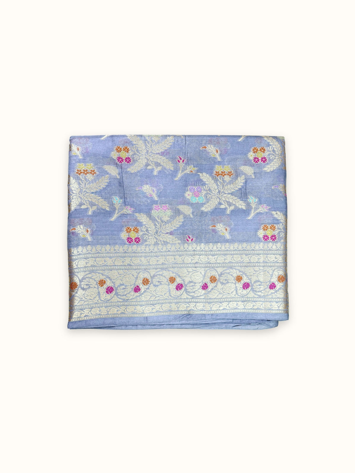 Slate blue Tassar silk saree folded, with silver leaf sprays and a floral border